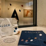 Expositions paris mai 2026 : invitation froissée, brochure et œuvres Calder en vitrine